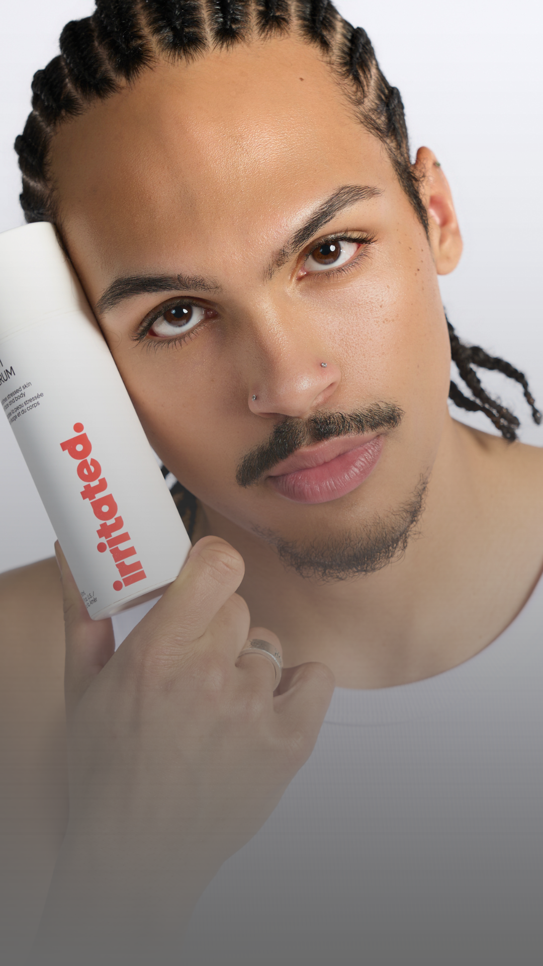 Xavier Leonard holding Irritated serum clinically tested non comedogenic safe for acne prone skin
